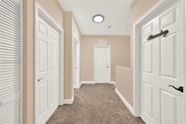 hall with light colored carpet