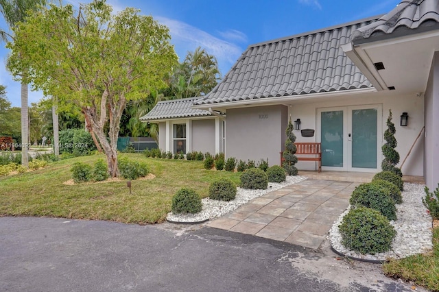 entrance to property featuring french doors and a yard