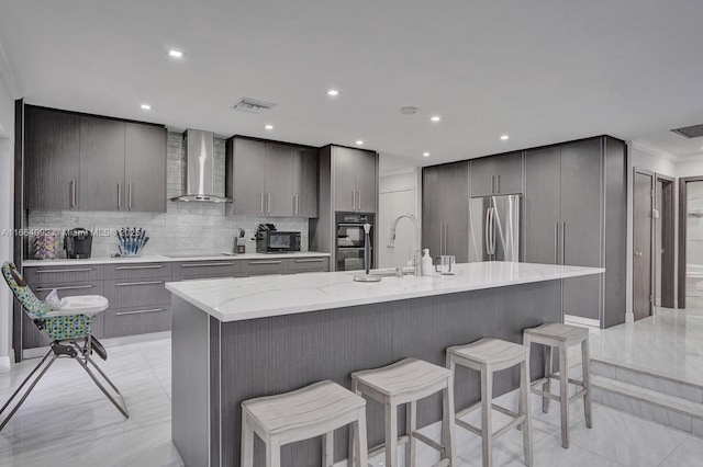 kitchen with visible vents, stainless steel refrigerator, cooktop, dobule oven black, and wall chimney exhaust hood