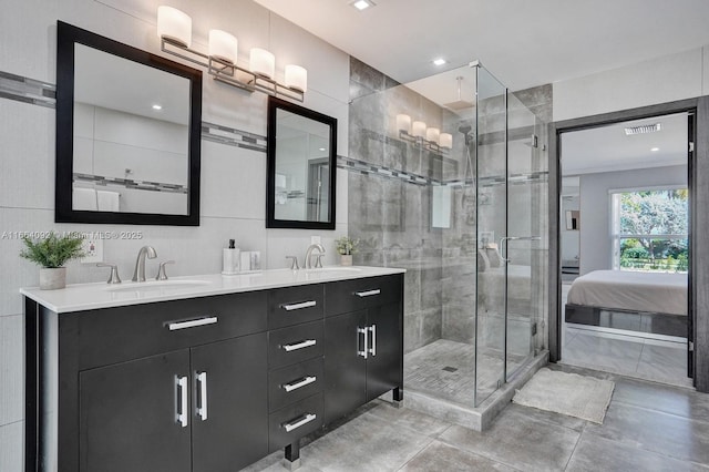 bathroom with a sink, a stall shower, and double vanity