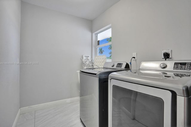 laundry room with laundry area, baseboards, and separate washer and dryer