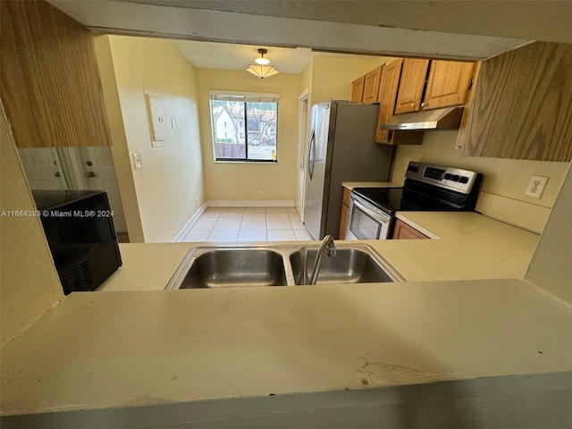 kitchen with kitchen peninsula, sink, light tile patterned floors, and stainless steel appliances