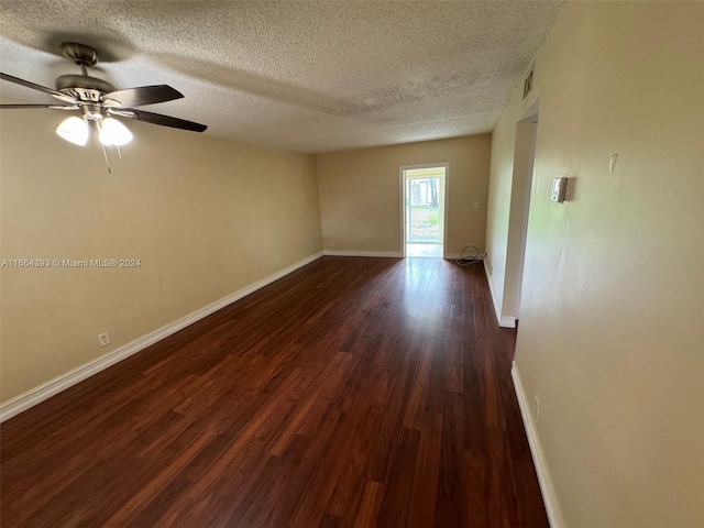 spare room with ceiling fan, dark wood-type flooring, and a textured ceiling