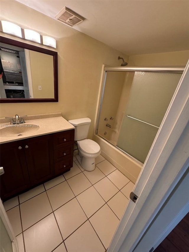 full bathroom with shower / bath combination with glass door, vanity, toilet, and tile patterned floors