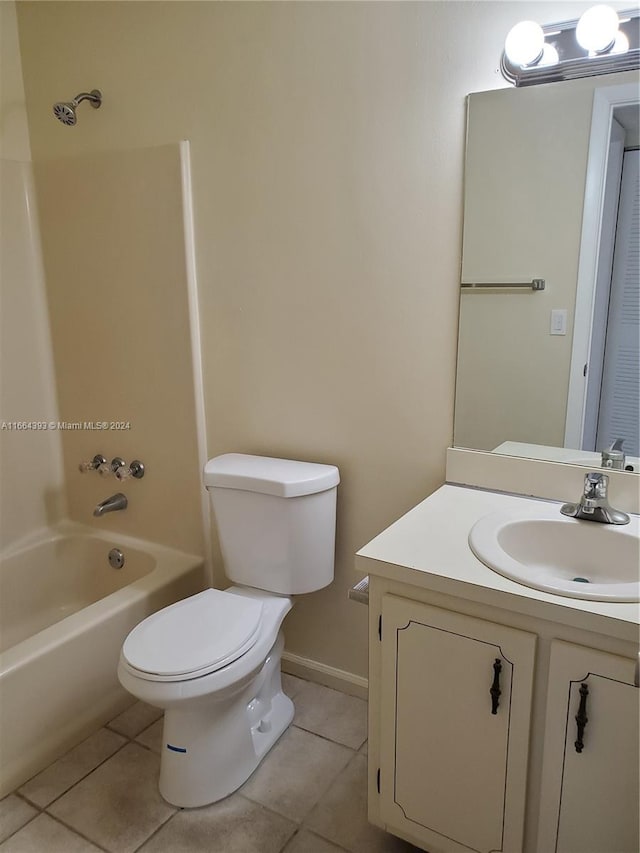 full bathroom with washtub / shower combination, vanity, toilet, and tile patterned floors