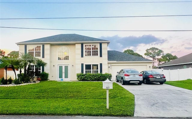 colonial house with a front yard and a garage