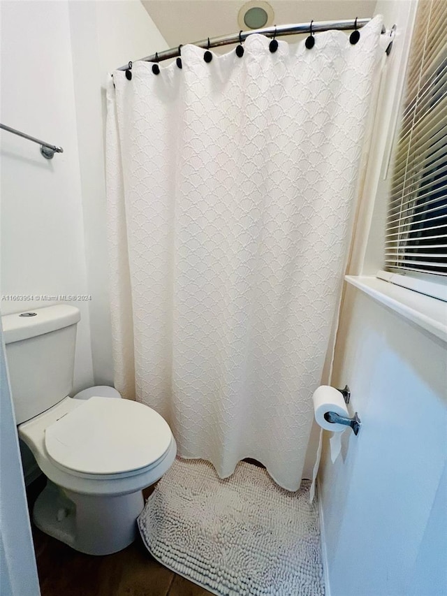 bathroom with walk in shower and toilet