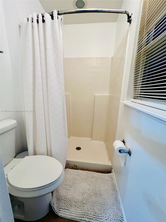 bathroom with toilet and curtained shower