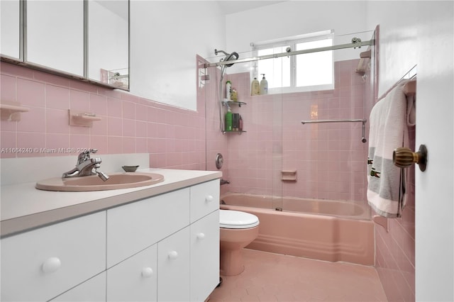 full bathroom featuring tile walls, vanity, tile patterned flooring, toilet, and tiled shower / bath