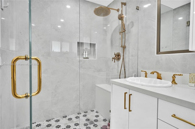 bathroom with tile walls, vanity, and an enclosed shower