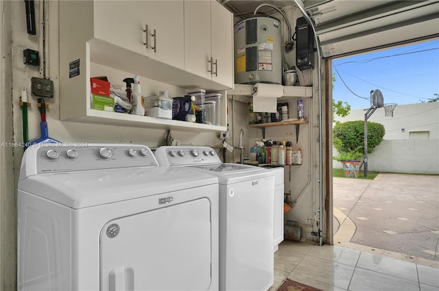 clothes washing area featuring washer and clothes dryer, electric water heater, and light tile patterned floors