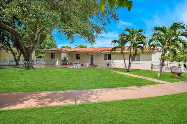 1407 San Marco Ave, Coral Gables, FL 33134 - ranch-style house featuring a front yard, a tiled roof, fence, a patio, and stucco siding