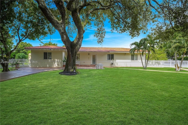 1407 San Marco Ave, Coral Gables, FL 33134 - back of property featuring a yard, stucco siding, fence, and a tiled roof