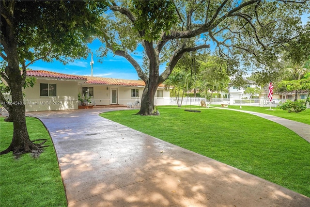 1407 San Marco Ave, Coral Gables, FL 33134 - view of front of property featuring stucco siding, driveway, a front yard, a tile roof, and fence