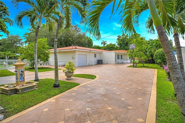 1407 San Marco Ave, Coral Gables, FL 33134 - ranch-style home with a front yard, a tiled roof, an attached garage, stucco siding, and curved driveway
