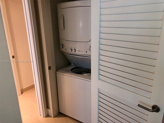 laundry area featuring light tile patterned floors and stacked washer and clothes dryer