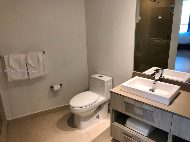 bathroom with tile patterned flooring, a shower with shower door, vanity, and toilet