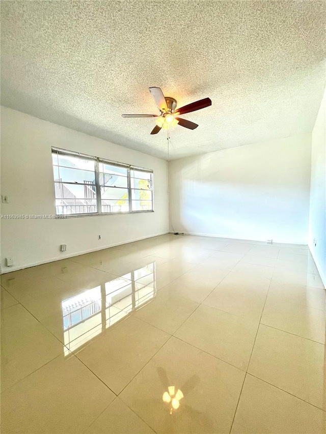 spare room with a textured ceiling and ceiling fan