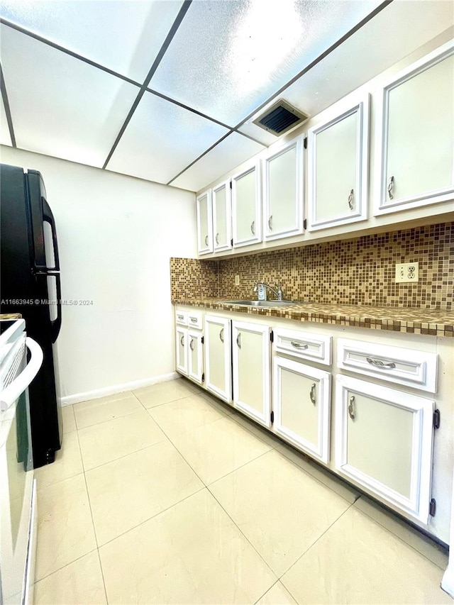 kitchen featuring white cabinets, light tile patterned flooring, and tasteful backsplash