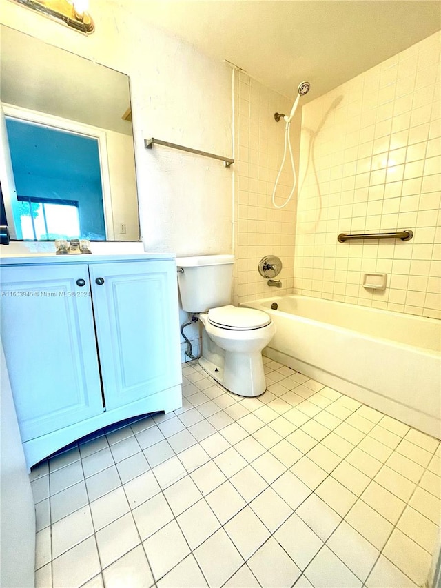 full bathroom featuring tile patterned flooring, tiled shower / bath combo, vanity, and toilet