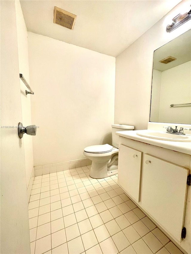 bathroom featuring tile patterned flooring, vanity, and toilet