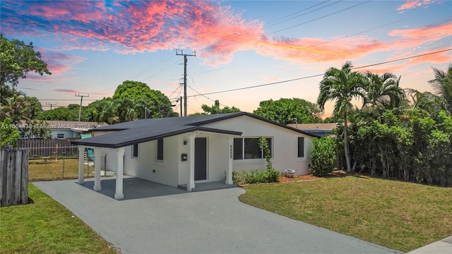 view of front of house with a patio and a yard