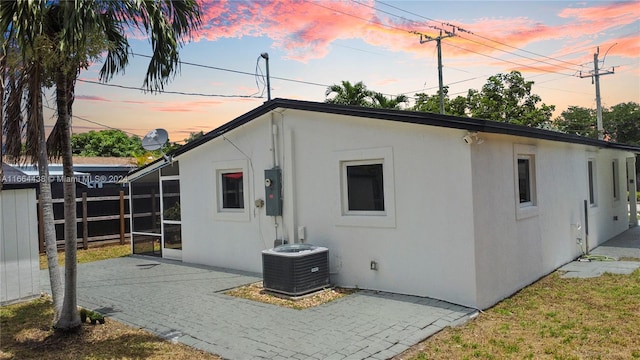 back house at dusk with a patio area and central AC