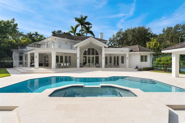 back of house featuring a pool with hot tub, a balcony, and a patio area