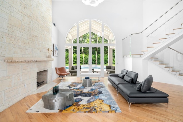 living room featuring a fireplace, a high ceiling, and light wood-type flooring