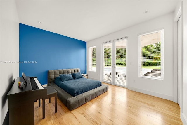 bedroom featuring french doors, light wood-type flooring, and access to outside