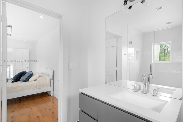 bathroom with an enclosed shower, wood-type flooring, and vanity