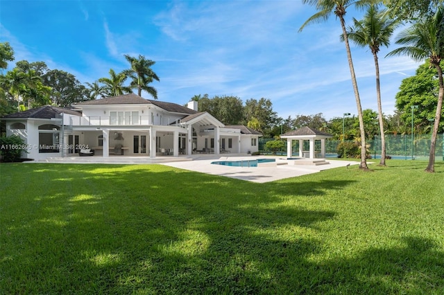 back of property with a yard and a patio