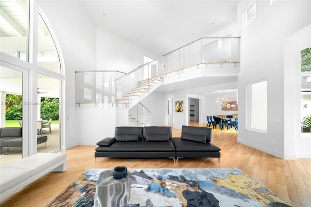 living room with hardwood / wood-style floors, a wealth of natural light, and high vaulted ceiling