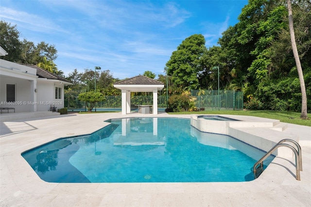 view of swimming pool featuring a patio, a gazebo, and an in ground hot tub