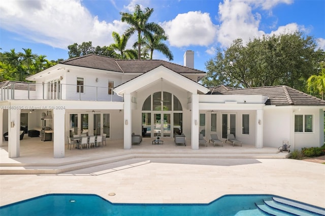 rear view of property featuring a patio, french doors, and a balcony