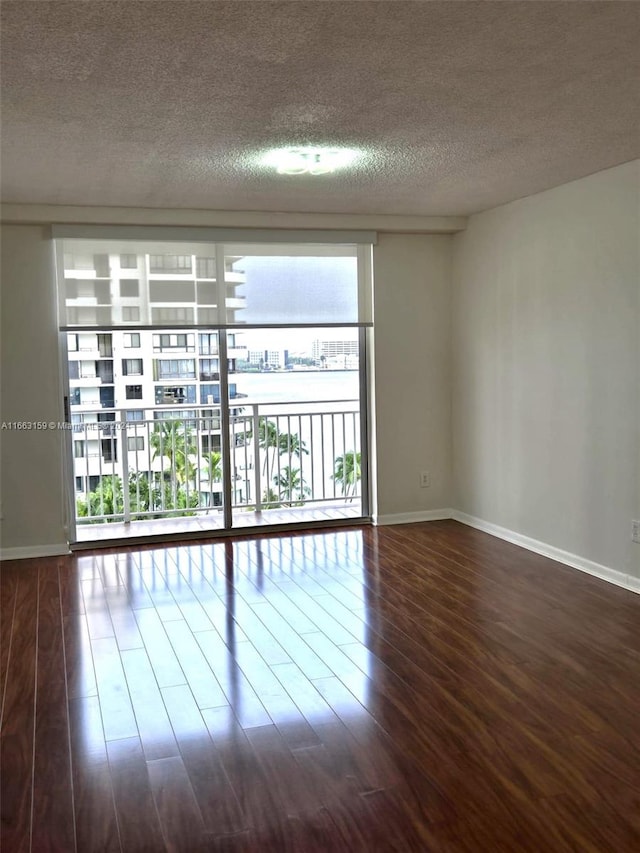 spare room featuring a textured ceiling and hardwood / wood-style floors