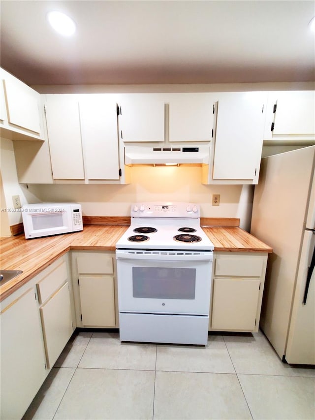 kitchen featuring light tile patterned flooring, white appliances, and white cabinetry