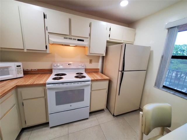 kitchen with white appliances, white cabinetry, and light tile patterned floors