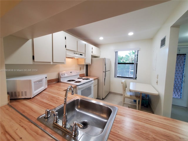 kitchen with white appliances, sink, light hardwood / wood-style flooring, and white cabinets