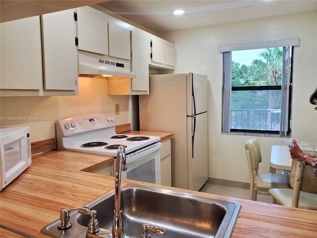 kitchen with white appliances, light hardwood / wood-style floors, white cabinetry, and sink