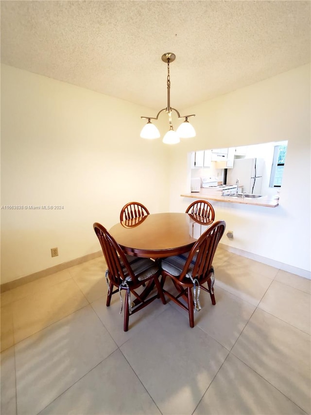 dining area featuring a textured ceiling and a notable chandelier