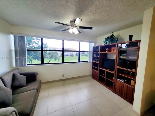 living room featuring ceiling fan and a textured ceiling