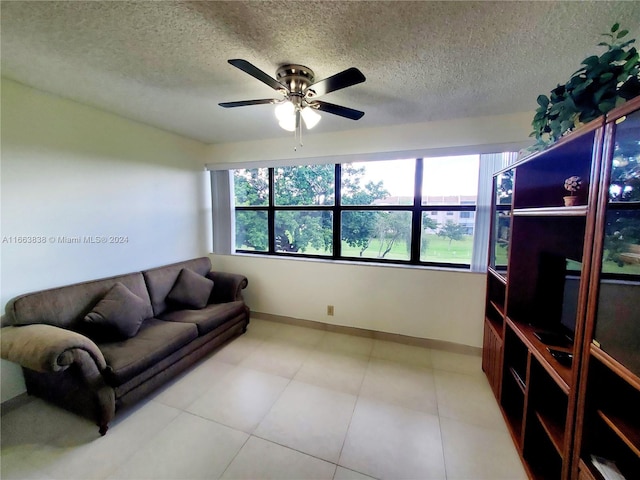 living room with ceiling fan and a textured ceiling