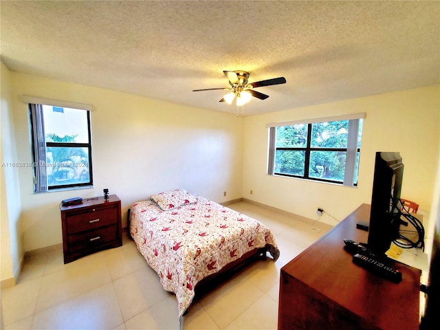 bedroom with multiple windows, a textured ceiling, and ceiling fan