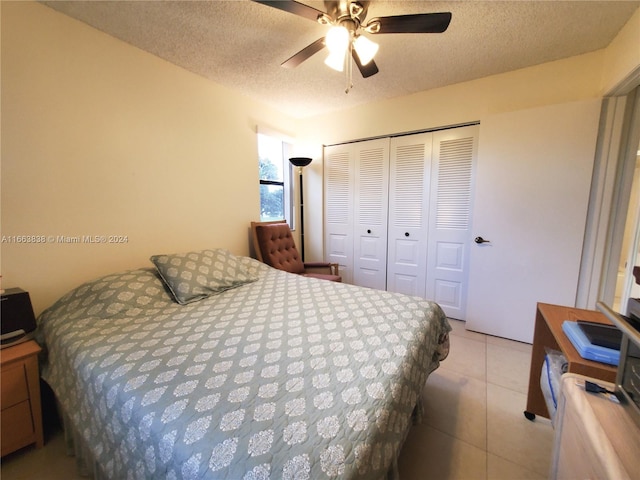 tiled bedroom featuring a textured ceiling, ceiling fan, and a closet