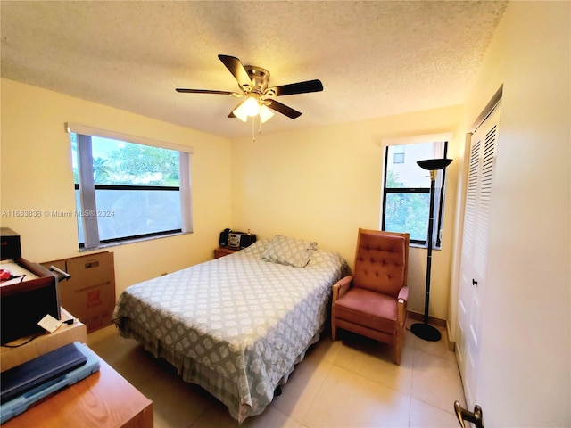 bedroom featuring ceiling fan, a textured ceiling, and a closet