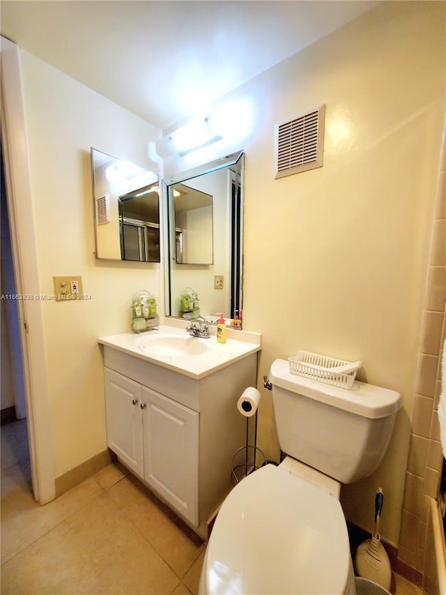 bathroom featuring walk in shower, vanity, tile patterned flooring, and toilet