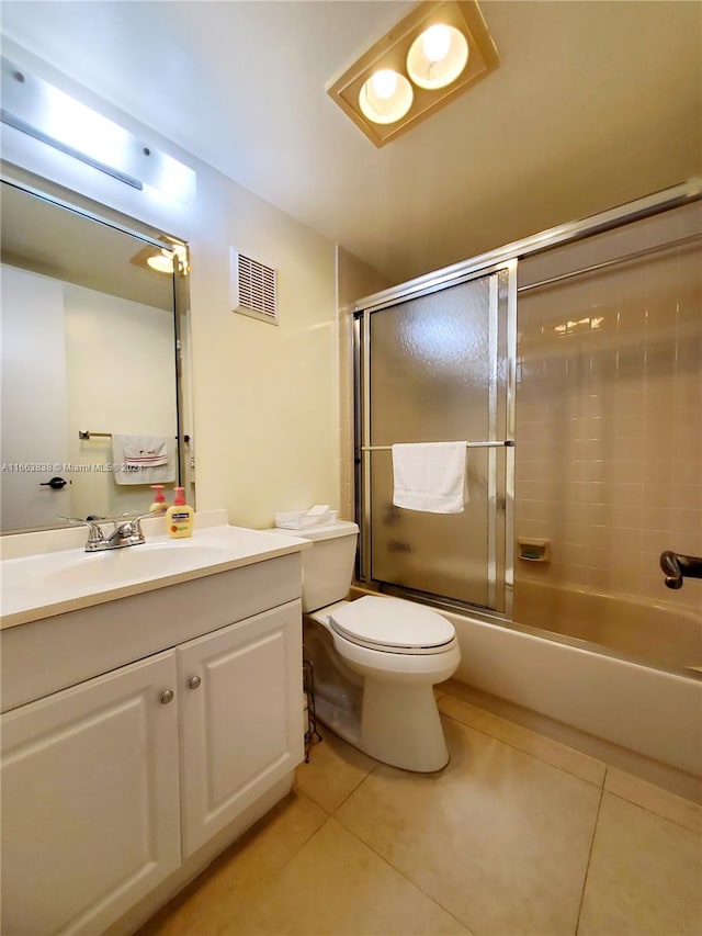 full bathroom featuring tile patterned flooring, vanity, toilet, and bath / shower combo with glass door