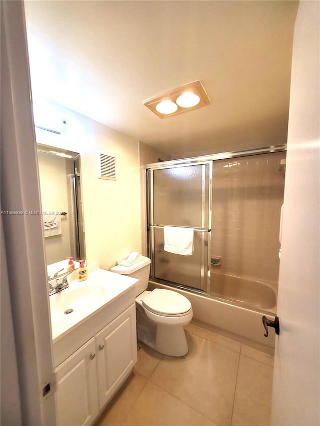 full bathroom featuring shower / bath combination with glass door, tile patterned flooring, vanity, and toilet