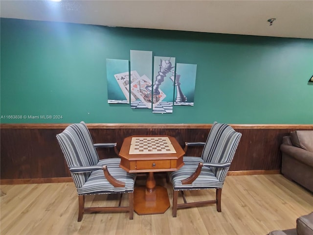 living area with light hardwood / wood-style flooring and wood walls